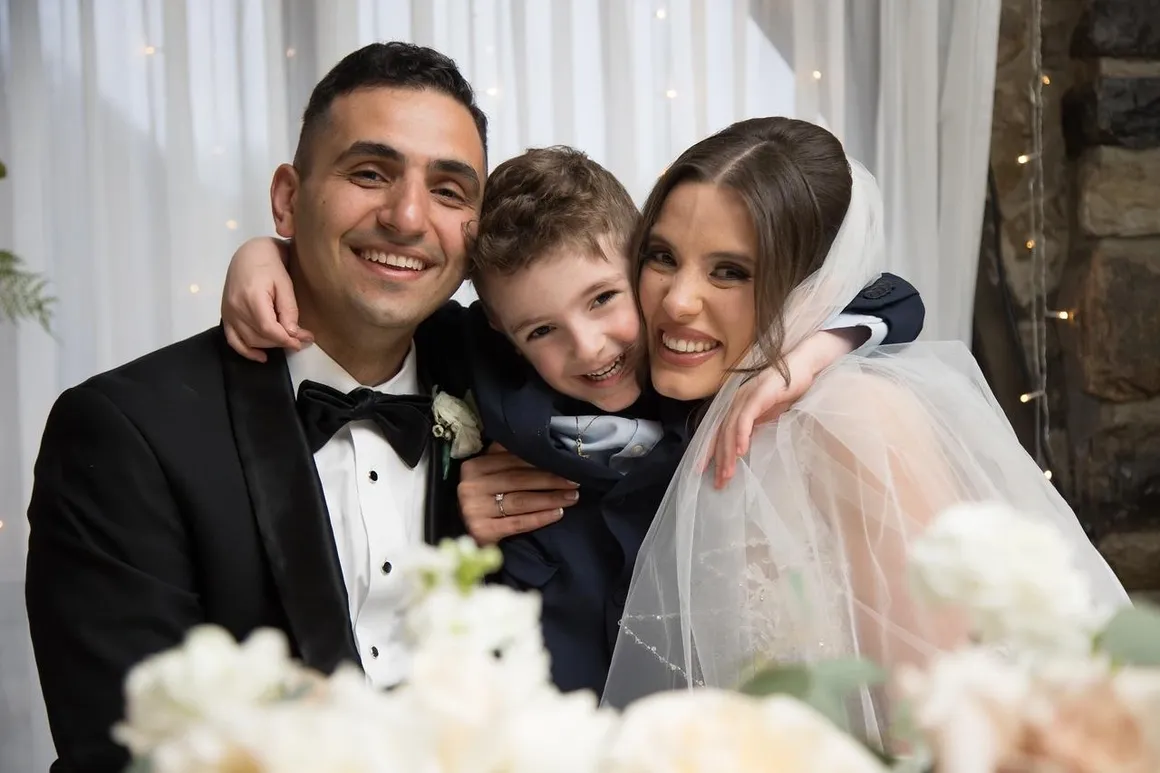 Bride and groom hugging their young son after the ceremony
